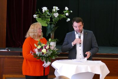 Übergabe des Blumenstrauß von Adrian Schäfer an Marita Tolksdorf Krüwel